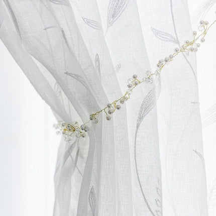 Valoverho kirjaillulla lehtikuviolla