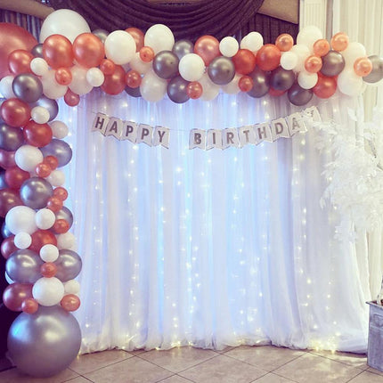 Pitkä valkoinen valoverho hääkaareen