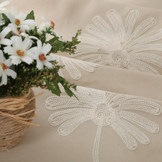 Harmaa verho brodeeratuilla päivänkakkaroilla