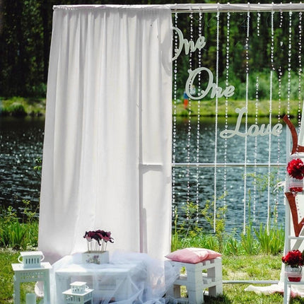 Pitkä valkoinen valoverho hääkaareen
