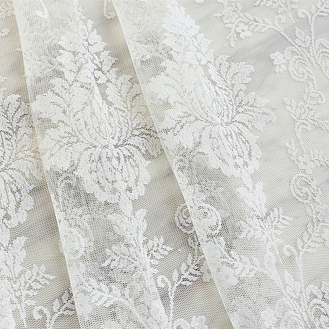 Valkoinen pitsiverho romanttisella kukkakuviolla