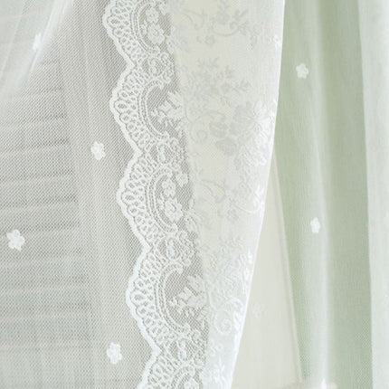 Valkoinen pitsikuvioinen valoverho olohuoneeseen