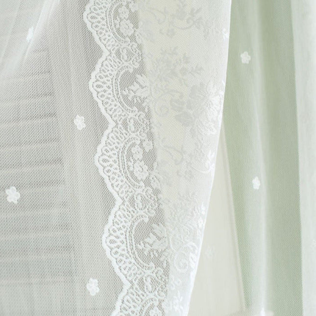 Valkoinen pitsikuvioinen valoverho olohuoneeseen