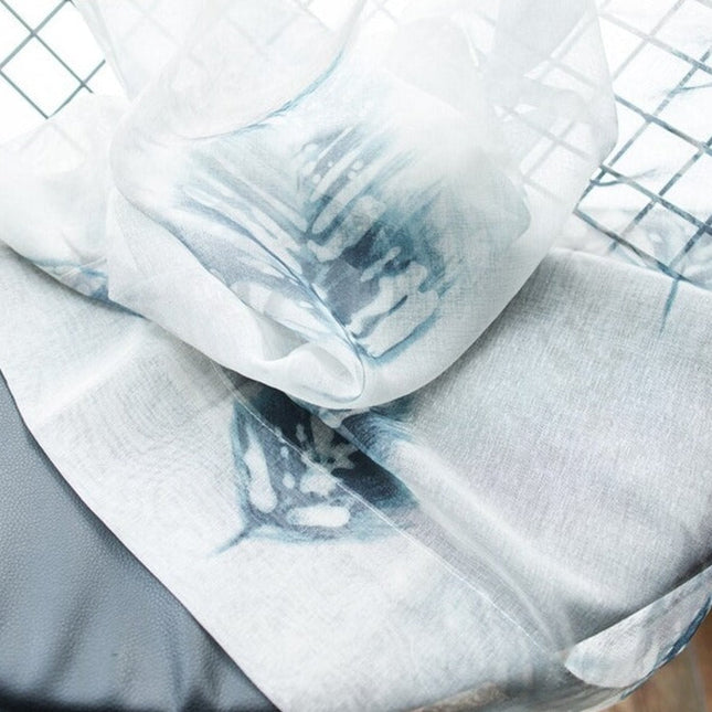 Valkoinen valkoverho sinisellä lehtikuviolla