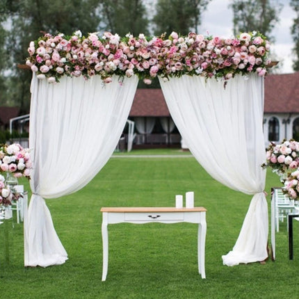 Pitkä valkoinen valoverho hääkaareen