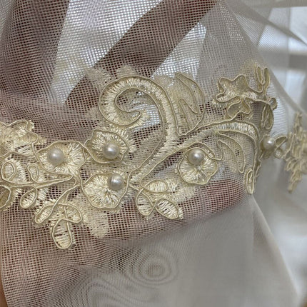 Valkoverho leveällä kultaisella kirjontareunuksella