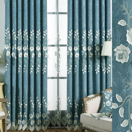 Sinivalkoinen verho kirjailluilla kukilla