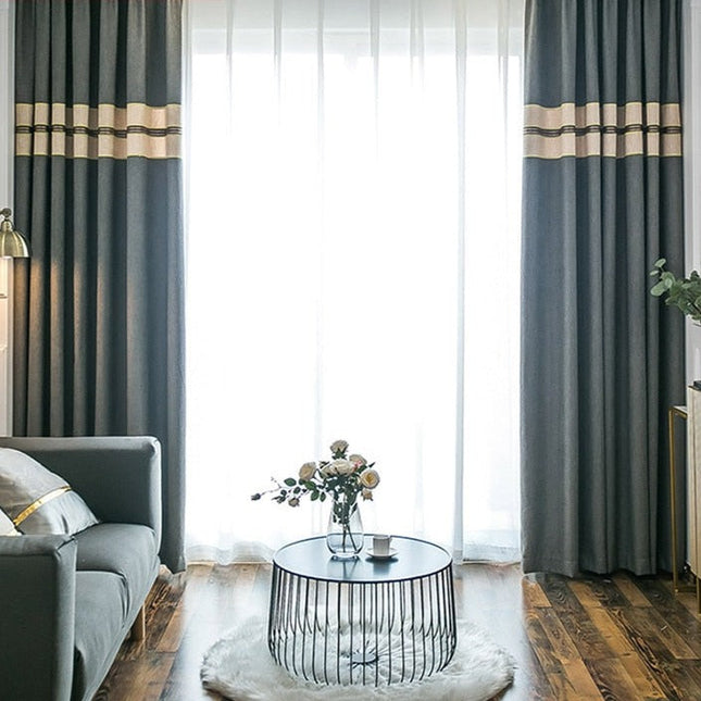 Harmaa verho beigellä koristereunalla