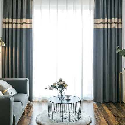 Harmaa verho beigellä koristereunalla