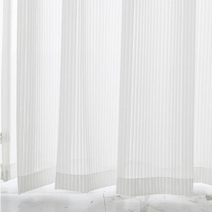 Valkoinen pystysuoraan laskostettu valkoverho