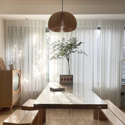 Valkoinen pystysuoraan laskostettu valkoverho