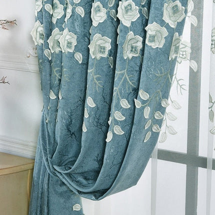 Sinivalkoinen verho kirjailluilla kukilla