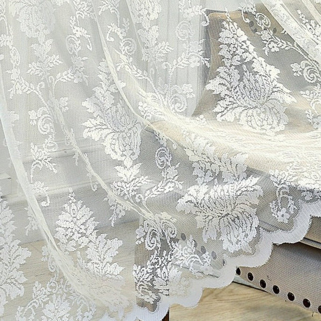 Valkoinen pitsiverho romanttisella kukkakuviolla