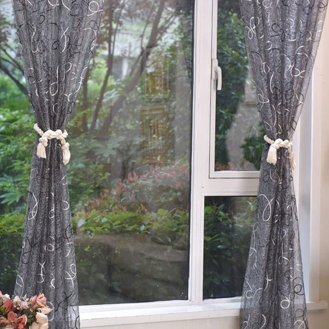 Harmaa valoverho koristeellisella kirjailulla