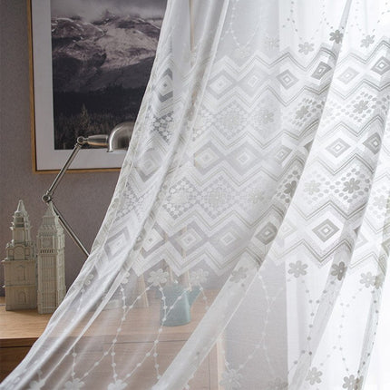 Kirjailtu valkoverho geometrisella kukkakuviolla
