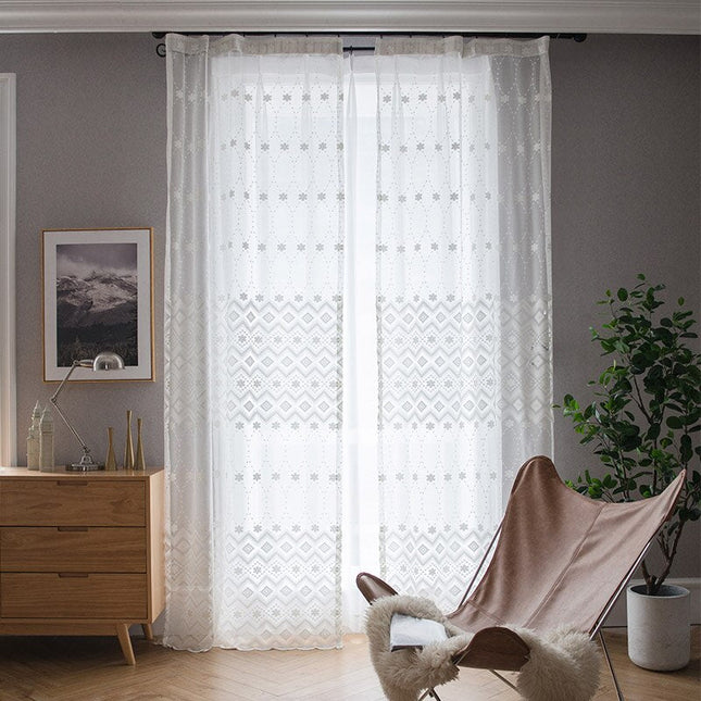 Kirjailtu valkoverho geometrisella kukkakuviolla