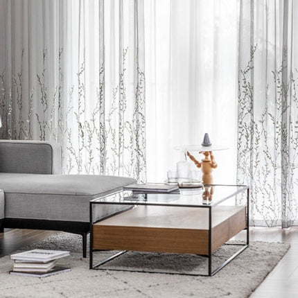 Läpikuultava verho kirjaillulla oksakuviolla