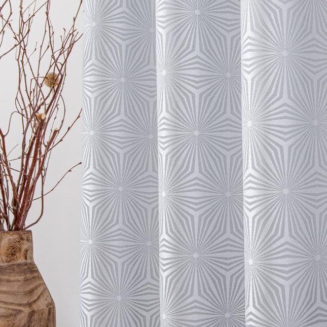 Vaaleanharmaa verho geometrisella tähtikuviolla