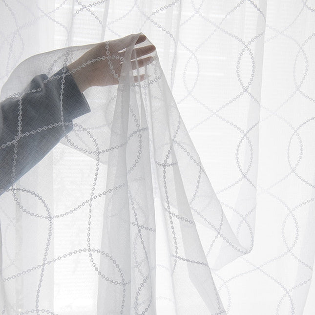 Valkoinen valoverho geometrisella kuviolla