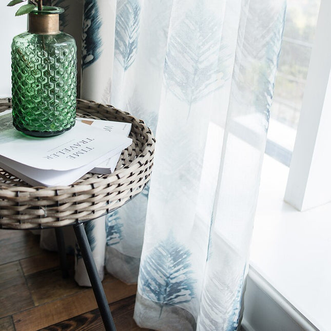 Valkoinen valkoverho sinisellä lehtikuviolla