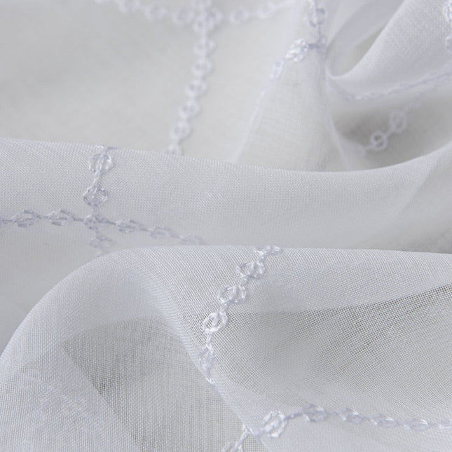 Valkoinen valoverho geometrisella kuviolla