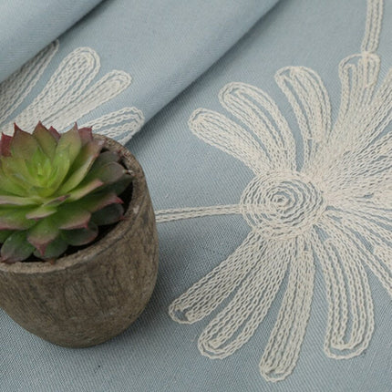 Harmaa verho brodeeratuilla päivänkakkaroilla