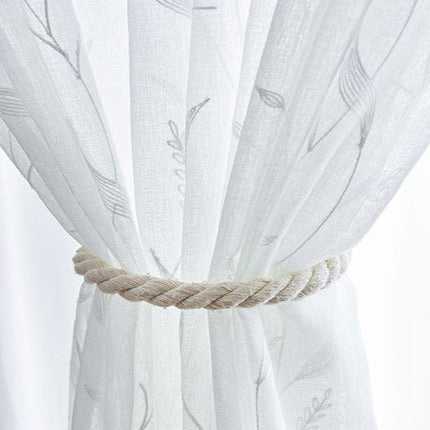 Kirjailtu valoverho ohuella kasvi-kuviolla