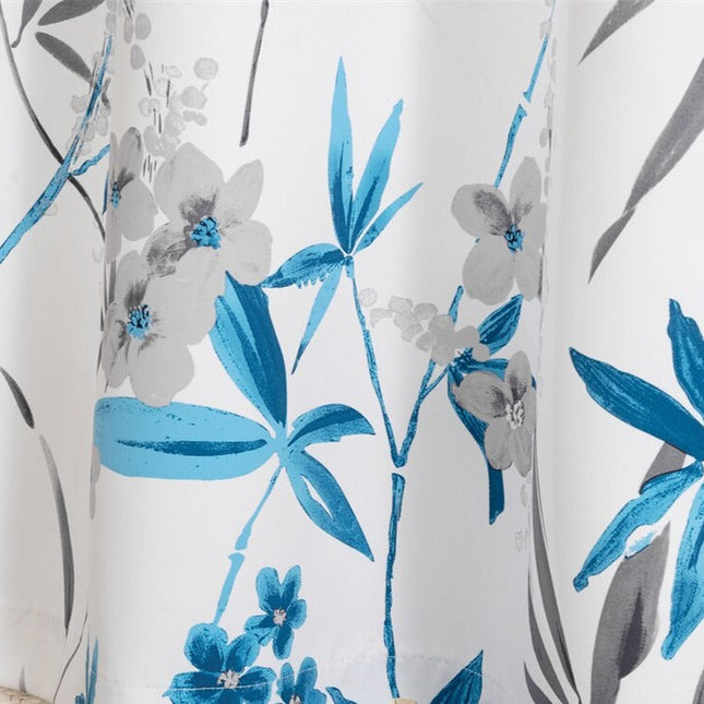 Valkoinen verho sinisellä kukkakuviolla