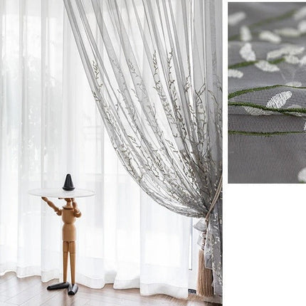 Läpikuultava verho kirjaillulla oksakuviolla