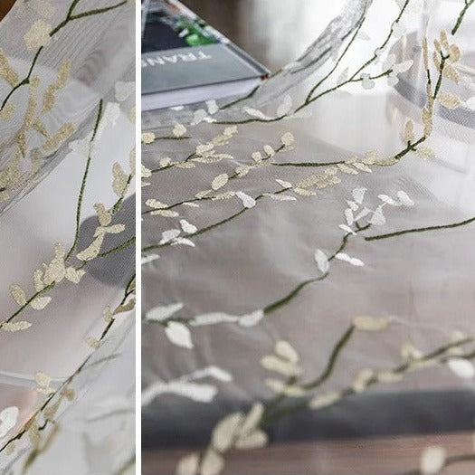 Läpikuultava verho kirjaillulla oksakuviolla