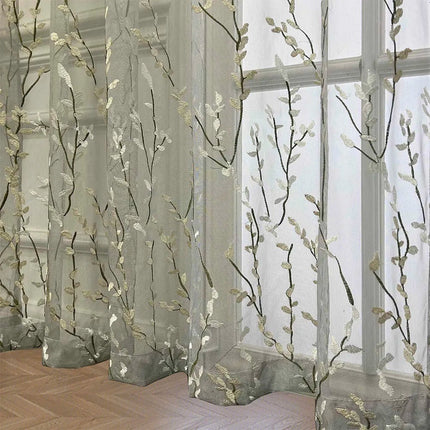 Läpikuultava verho kirjaillulla oksakuviolla
