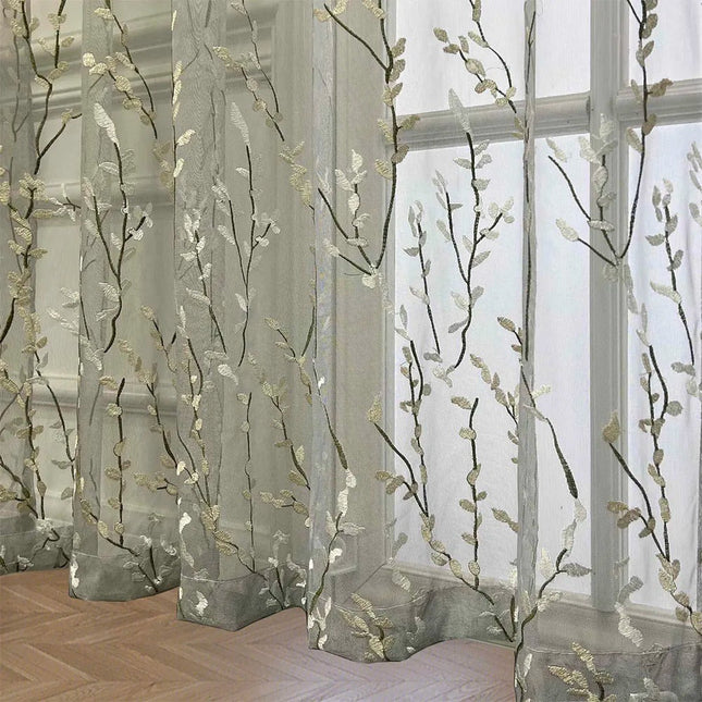 Läpikuultava verho kirjaillulla oksakuviolla